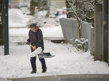 A man shovels a sidewalk on West 8th near Ontario during Friday's snowstorm.