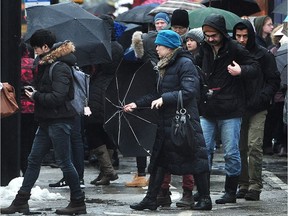 VANCOUVER, BC. Soaked commuters wait for buses at the Commercial St skytrain station in Vancouver, BC., (NICK PROCAYLO/PostMedia)