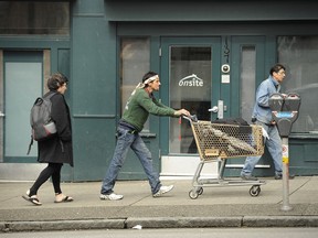 FILE PHOTO: A man walks past the OnSite location at 137 East Hastings during a Downtown Eastside Woman's march in Vancouver, BC., on September 17, 2011. A Vancouver pharmacy is suing a former manager over the handling of an alleged drug overdose in the facility.