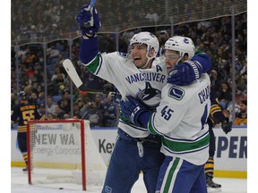 Vancouver Canucks Alexandre Burrows (14) and Michael Chaput (45) celebrate a goal during the second period of an NHL hockey game against the Buffalo Sabres, Sunday, Feb. 12, 2017, in Buffalo, N.Y.