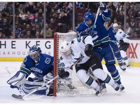 Vancouver Canucks defenceman Philip Larsen (63) looks on as San Jose Sharks centre Ryan Carpenter (40) tries to get a shot past Vancouver Canucks goalie Ryan Miller (30) during first period NHL action in Vancouver, B.C. Thursday, Feb. 2, 2017.