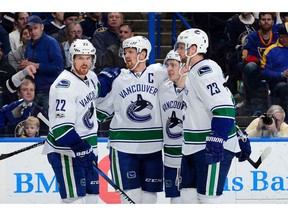 Henrik Sedin is congratulated by teammates after scoring a goal agains the St. Louis Blues on Thursday.