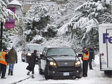 Vehicles are seen stuck on a small snow covered hill in North Vancouver, B.C., Friday, Feb. 3, 2017. Heavy snow hit the northshore leaving cars and trucks slipping and sliding.