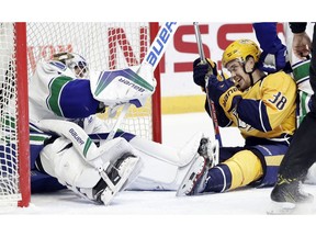 Nashville Predators left wing Viktor Arvidsson (38), of Sweden, laughs after he and Vancouver Canucks goalie Jacob Markstrom (25), also of Sweden, both ended up on the ice during the second period of an NHL hockey game Tuesday, Feb. 7, 2017, in Nashville, Tenn.