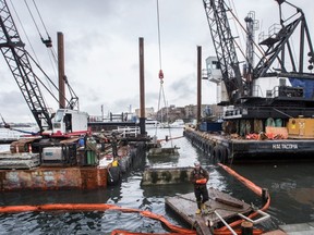 Workers remove the pilings for the former Pacific Undersea Gardens to make way for a new dock for the V2V Empress, a 254-passenger, 126-foot ferry that will provide service between downtown Victoria and downtown Vancouver.