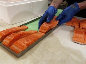 In this Friday, April 10, 2015 photo, Canadian certified organic farm-raised King Salmon filets are placed on a tray in a store in Fairfax, Va. Overeating or under-eating 10 foods and nutrients contributes to nearly half of U.S. deaths from heart disease, strokes and diabetes, a study released on Tuesday, March 7, 2017, suggests. &ampquot;Good&ampquot; foods that were under-eaten include: nuts and seeds, seafood rich in omega-3 fats including salmon and sardines; fruits and vegetables; and whole grains. (AP Pho