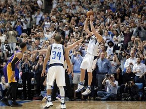 Dallas Mavericks&#039; Devin Harris (34) watches as Dirk Nowitzki (41) of Germany takes a shot that sinks giving Nowitzki his 30,000th career point in the first half of an NBA basketball game against the Los Angeles Lakers in Dallas, Tuesday, March 7, 2017. (AP Photo/Tony Gutierrez)