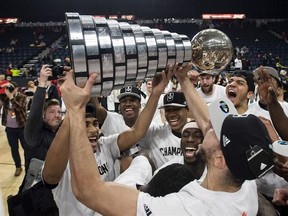Members of the Carleton Ravens men&#039;s basketball team raise the W.P McGee Trophy following their win over the Ryerson Rams in the USports basketball national championship game in Halifax on Sunday, March 12, 2017. THE CANADIAN PRESS/Darren Calabrese