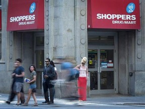 People pass by a Shoppers Drug Mart in downtown Toronto on Monday, July 15, 2013. Shoppers Drug Mart says a computer outage affecting all of its 1,300-plus locations is preventing customers paying with their debit cards and using their loyalty points program. THE CANADIAN PRESS/Graeme Roy