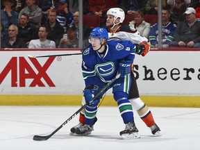 Brock Boeser of the Vancouver Canucks is checked by Kevin Bieksa during in a game at Rogers Arena Tuesday, March 28, 2017 in Vancouver.
