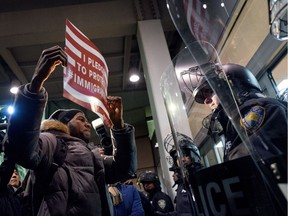A protester faces police officers at an entrance of Terminal 4 at John F. Kennedy International Airport in New York on Jan. 28, 2017, in the wake of new U.S. President Donald Trump’s executive orders imposing restrictions on immigration from seven Muslim-majority countries and stepping up border enforcement.