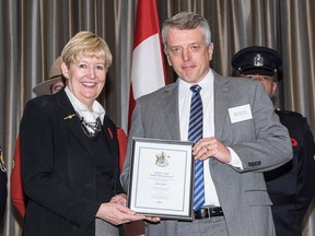 Then-active Vancouver Police Department Det. Const. Jim Fisher (right) receives an award from B.C. Attorney General Suzanne Anton at an October 2014 event in Burnaby. Fisher is currently suspended and facing charges including sexual exploitation, sexual assault and obstructing justice.