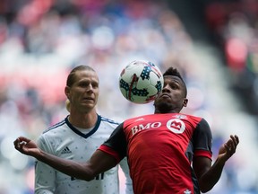 Toronto FC midfielder Armando Cooper, right, knocks the ball down in front of Whitecaps midfielder Brek Shea during the first half of an MLS game in Vancouver on Saturday.