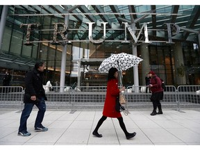 Pedestrians walk by the Trump International Tower and Hotel in Vancouver. The official opening was held Feb. 28, 2017 in Vancouver.