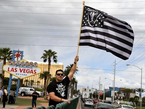 Oakland Raiders fan Matt Gutierrez of Nevada waves a Raiders flag in front of the ‘Welcome to Fabulous Las Vegas’ sign after National Football League owners voted 31-1 to approve the team's application to relocate to Las Vegas at their annual meeting on Monday in Phoenix.