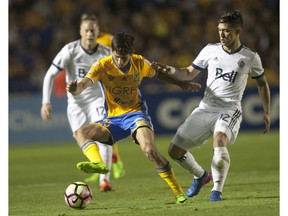 Jürgen Damm (L) of Tigres vies for the ball with Fredy Montero (R).