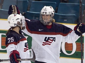 FILE - In this Nov. 4, 2014, file photo, Team United States' Monique Lamoureux, right, celebrates her goal against Team Finland with teammate Alex Carpenter during the third period at the Four Nations Cup women's hockey tournament in Kamloops, British Columbia. The U.S. women's hockey team is threatening to boycott the world championships because of a wage dispute. The team announced Wednesday that they will not participate in the International Ice Hockey Federation tournament that begins March 31, 2017, in Plymouth, Michigan.