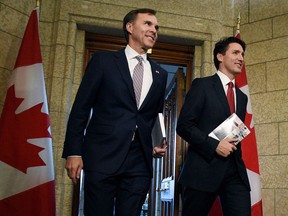 Finance Minister Bill Morneau and Prime Minister Justin Trudeau leave the Prime Minister's office holding copies of the federal budget in Ottawa, Wednesday, March 22, 2017.
