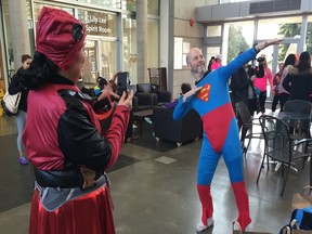 Bradley Cuzen fashions his special Superman outfit inside the West Van Community Centre lobby before Saturday's West Van Run 5K. Clubmate Debra Kato, in her Deadpool costume, gets ready to take a photo. More than 600 people took part in the 5K.