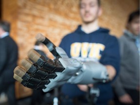 FILE PHOTO Michael Peirone, a fourth-year biomedical engineering student at the University of Victoria, displays a 3D printed hand that engineers have produced for amputees in developing countries.