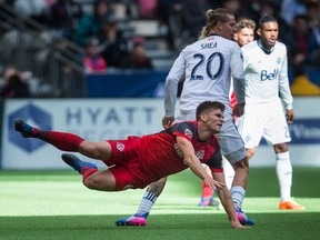 Toronto FC's Nick Hagglund, front, is sent flying after colliding with Vancouver Whitecaps' Brek Shea during second half MLS soccer action in Vancouver, B.C., on Saturday, March 18, 2017. Shea collected a red card and was ejected from the match.