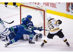 Boston Bruins left wing Brad Marchand (63) is stopped by Vancouver Canucks goalie Ryan Miller (30) as defenceman Luca Sbisa (5), of Italy, defends during the first period of an NHL hockey game in Vancouver, B.C., on Monday March 13, 2017.