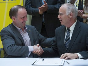 B.C. Education Minister Mike Bernier, left, announces an infusion of $217 million to build up to 5,200 new student spaces in the Surrey School District at a news conference in the city on Jan. 26. Here, Bernier signed a letter of understanding with Shawn Wilson, board chairman of the Surrey district.