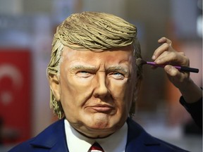 Turkish pastry chef Tuba Geckil adds the finishing touches to her figure of US President Donald Trump made out of cake icing which she created in two days, during a chocolate show in Istanbul, Saturday, March 25, 2017.