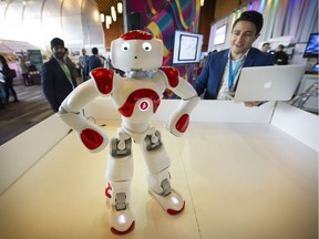 Nizar Mohamed looks over "NAO", a new cognitive robot, as it is put through his paces at the B.C. Tech Summit at the Vancouver Convention Centre.