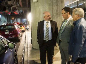 Energy Minister Bill Bennett talks to representatives of the New Car Dealers Association of B.C. — CEO Blair Qualey and Chair Jim Inkster — at the Vancouver International Auto Show this week.