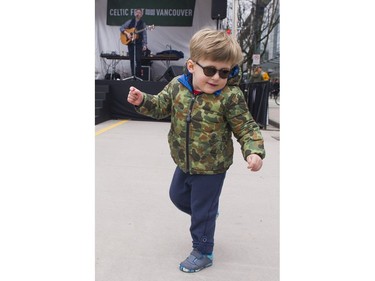 Three year old Oliver dances as Bruce Coughlan performs at the Celtic Fest set up on Robson st to celebrate St. Patrick's Day Vancouver March 17 2017.