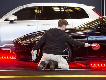 Oliver Auer dusts an Aston Martin DB 11 on display at the Vancouver Auto Show held at Vancouver Convention Centre West, Vancouver March 28 2017.