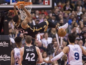 Toronto Raptors guard Norman Powell (24) slam dunks the ball as Philadelphia 76ers forward Dario Saric (9) looks on during second half NBA basketball action in Toronto on Sunday, April 2, 2017. THE CANADIAN PRESS/Nathan Denette