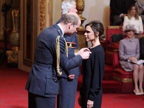Fashion designer Victoria Beckham, right, receives her OBE from Britain&#039;s Prince William, the Duke of Cambridge during an investiture ceremony at Buckingham Palace in London, Wednesday April 19, 2017. (Yui Mok/PA via AP)