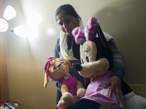 Balraj Gill holds the toys of her three-year-old daughter, Nimrat, in the family home in Abbotsford on Feb. 16. Nimrat died of an aggressive infectious disease Feb. 7.