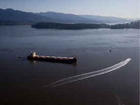 Crews on spill response boats work around the bulk carrier cargo ship Marathassa after a bunker fuel spill on Burrard Inlet in Vancouver on April 9, 2015. The company is facing charges related to the mishap in B.C. Provincial Court.