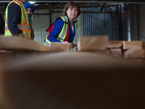 British Columbia Premier Christy Clark stacks lumber before speaking about U.S. import duties on Canadian softwood lumber, at Partap Forest Products in Maple Ridge, B.C., on Tuesday April 25, 2017.