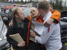 NDP supporter and retired teacher Bill Wilson (middle) is helped after nearly fainting after confronting Liberal party volunteer Andrew Roberts (left) outside a NDP party rally in Coquitlam on Thursday. Roberts was handing out Liberal party literature at the time. NDP press secretary James Smith (right) helps Roberts steady Wilson.