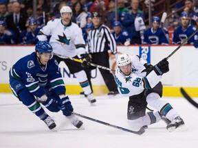 San Jose Sharks' Melker Karlsson, right, of Sweden, takes a shot that deflects off the stick of Vancouver Canucks' Griffen Molino during the third period of an NHL hockey game in Vancouver, B.C., on Sunday April 2, 2017.