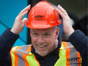 NDP Leader John Horgan straightens a hard hat after putting it on during a campaign stop at the International Union of Operating Engineers Local 115 Training Centre in Maple Ridge, B.C., on Tuesday April 18, 2017. A provincial election will be held on May 9.