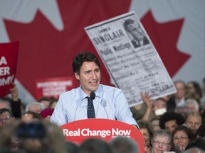 Justin Trudeau at an October 2015 campaign rally in North Vancouver, with a poster of his late grandfather James Sinclair — a Louis St. Laurent-era cabinet minister and Liberal MP — held up behind him. Millennial voters in B.C. flooded to Trudeau in that year’s election, but will they decisively back any one horse in next month’s B.C. vote?