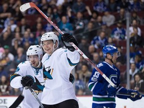 San Jose Sharks' Mikkel Boedker, left, of Denmark, and Tomas Hertl, of the Czech Republic, celebrate Hertl's goal as Vancouver Canucks' Henrik Sedin, right, of Sweden, looks on during the first period of an NHL hockey game in Vancouver, B.C., on Sunday April 2, 2017.