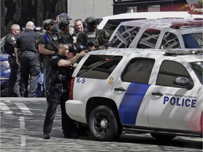 Police officers crowd a street adjacent to the scene of a shooting involving several police officers in downtown Seattle, Thursday, April 20, 2017.