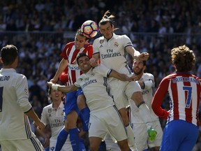 Real Madrid's Pepe, centre, and Gareth Bale, top right, fight for a high ball with Atletico Madrid's Diego Godin, top left, during the La Liga soccer match between Real Madrid and Atletico Madrid at the Santiago Bernabeu stadium in Madrid earlier this month. Pepe scored once and the match ended in a 1-1 draw. The two teams are headed for a Champions League showdown, as well.