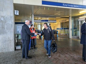 Langley Township Mayor Jack Froese, who is a member of the TransLink Mayors' Council, hands out a postcard to a SkyTrain user. The mayors are calling on all provincial parties to commit to funding the rest of a 10-year regional transportation plan. They launched an outreach campaign ahead of the provincial election.