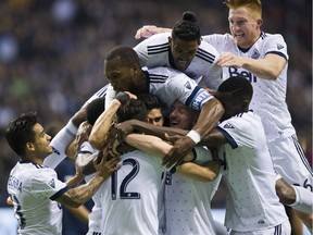 Whitecaps FC #15 Matías Laba disappears under his teammates after scoring against the LA Galaxy  in a regular season MLS soccer game at BC Place, Vancouver April 1, 2017.