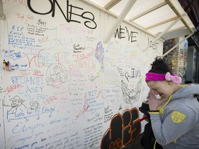 Natasha Loeffler breaks down after signing the memorial and message board for victims of the drug-overdose epidemic. The board was unveiled Tuesday in the Downtown Eastside at 62 East Hastings St. at Vancouver.