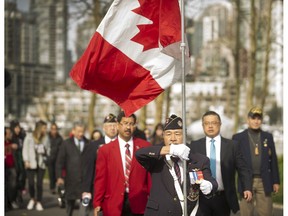 Alfred Woo of Pacific Unit 280 of the Army, Navy and Air Force Veterans in Canada, holds the Canadian flag as he leads the Rights and Freedoms March in Vancouver on Sunday.