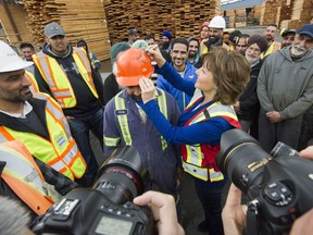 Premier Christy Clark signs the hard hat of Gary Dhaliwal at Partap Forest Products in Maple Ridge, B.C., April 25, 2017.