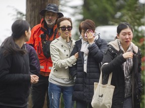 Family members talk with Search and Rescue teams as they try to find snowshoers missing on Mount Harvey near Lions Bay.